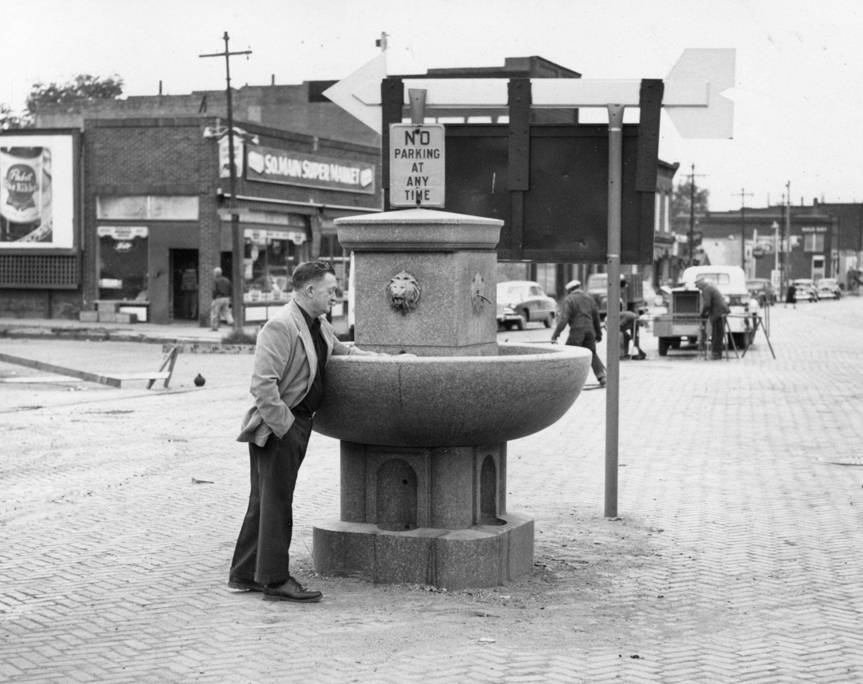 A citizen inspects the watering trough located at the V-intersection at Pearl and Main streets, October 14, 1952.