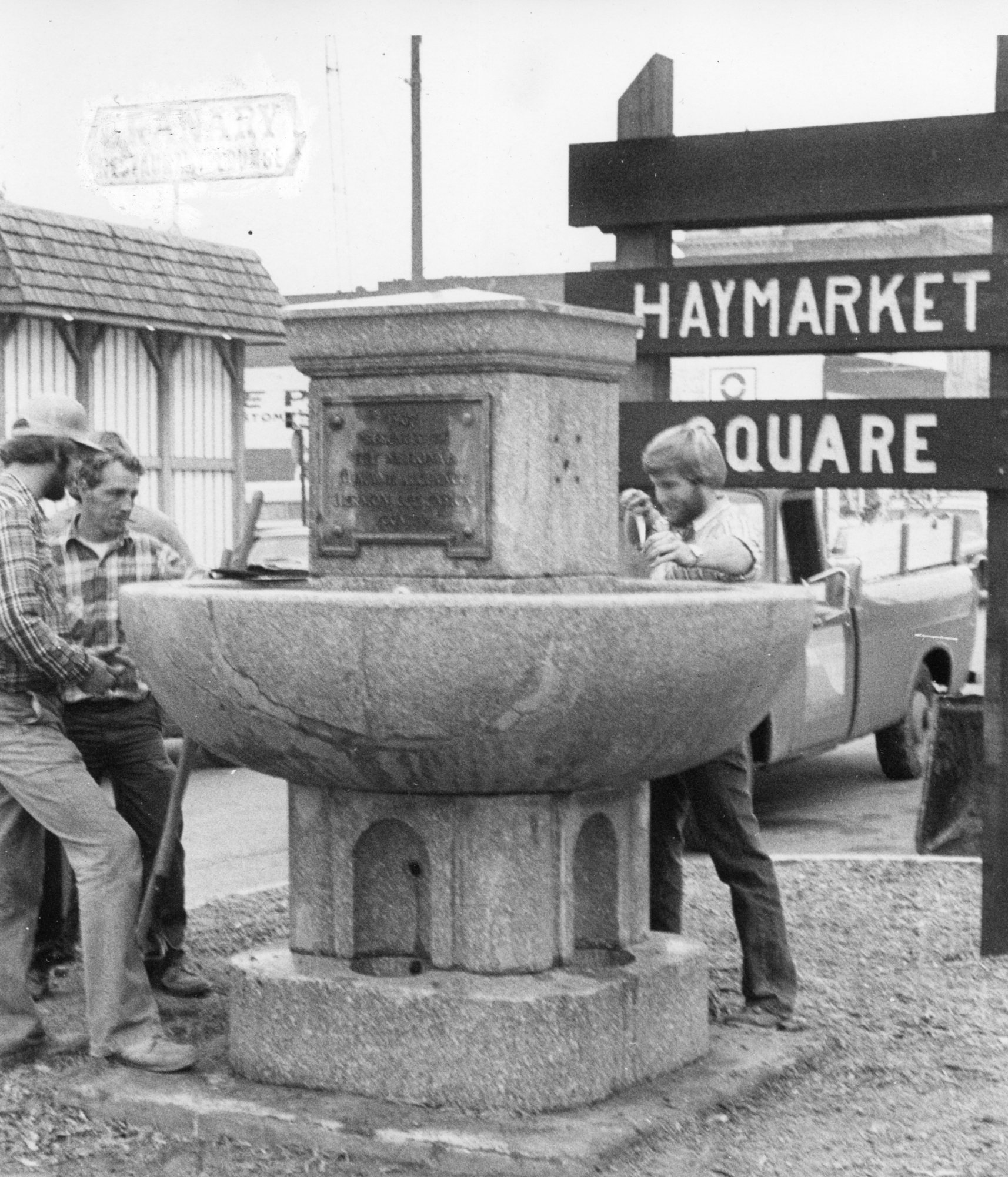 Parks department employees finish reinstalling the water trough at the intersection of Main and Pearl Streets, 1975.