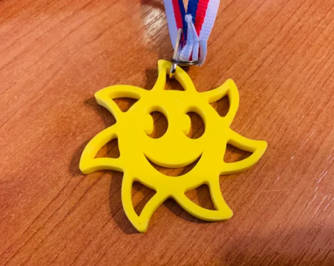 Photo of a sunshine charm with a smiley face.