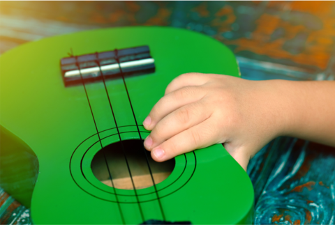Hand on a green ukulele.