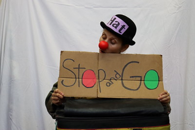 Clown holding a stop and go sign.