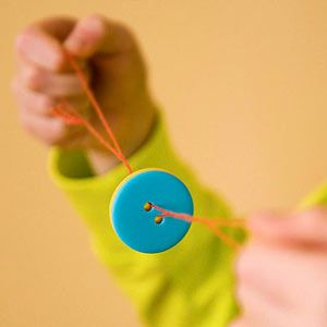 Child playing with a button whirligig.