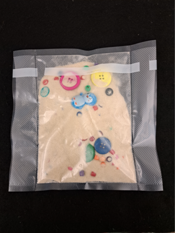 Bag with sand, buttons and small toys in it.