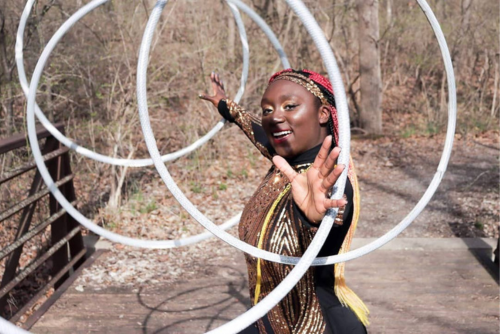 Woman twirling hula-hoops.